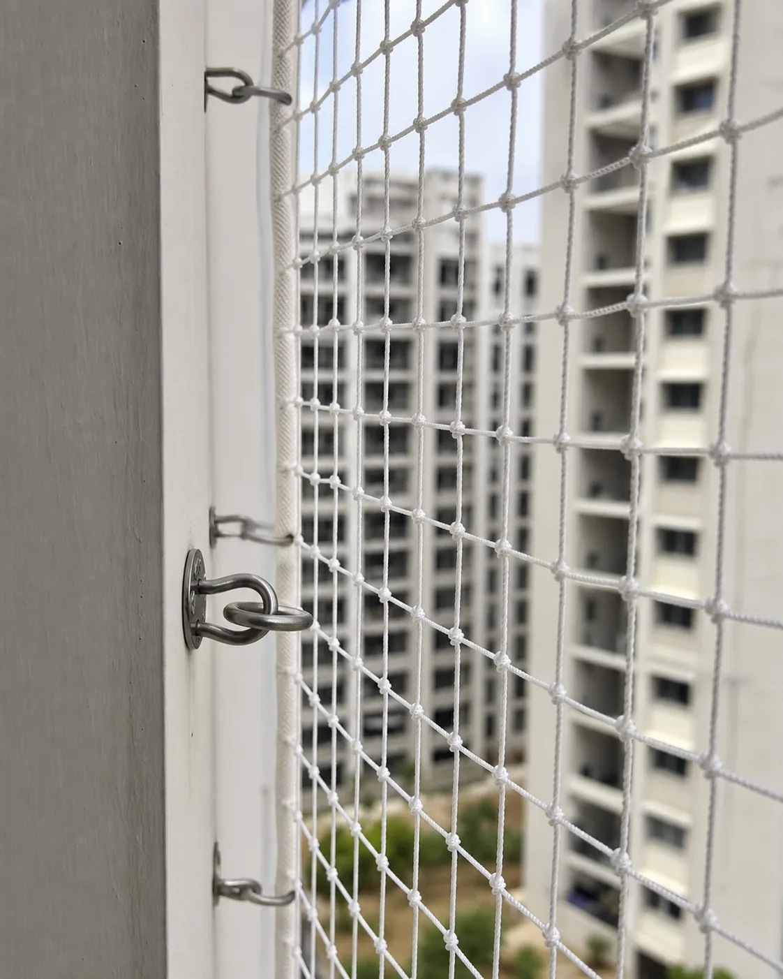 Close view of safety net mesh and stainless-steel balcony fittings